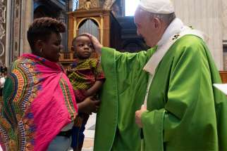 Pope Francis greets a woman and child during a July 8, 2019, Mass in St. Peter&#039;s Basilica at the Vatican commemorating the sixth anniversary of his visit to the southern Mediterranean island of Lampedusa.