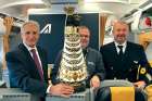 Fr. Chris Piasta, chaplain at the JFK and LaGuardia airports in New York, stands behind the Our Lady of Loreto statue flanked by the Alitalia flight crew.