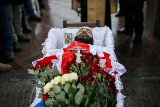 A crucifix and image of Christ are seen in the casket of Georgian Tomaz Sukhiashvili, a member of a self-defense battalion, during his Jan. 21 funeral in Kiev, Ukraine. The United Nations estimated that at least 224 civilians have been killed and another 545 people wounded since mid-January, raising the death toll to more than 5,300 people since April. 