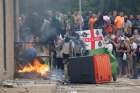 Demonstrators toss a trash bin during an anti-immigration protest in Rotherham, England, Aug. 4, 2024.