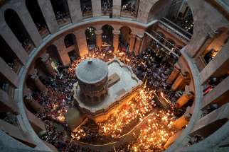Pilgrims carry candles inside the Edicule, the traditional site of Jesus&#039; burial and resurrection, in the Church of the Holy Sepulcher in the Old City of Jerusalem.