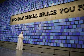 Pope Francis pauses in front of a display at the National 9/11 Memorial and Museum in New York Sept. 25. The Virgil quotation on the wall reads, &quot;No day shall erase you from the memory of time.&quot; 