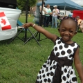 Two-year-old Abiba Doumbia poses with a Canadian flag at the Community Cup held at Brewer Park in Ottawa during the Community Cup.