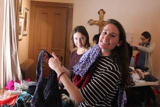 Katie Moretta, left, and Isabel Cumming look through piles of donated clothing during the annual St. Gianna clothing exchange.