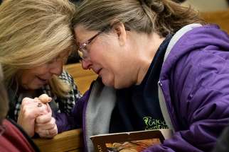 Judy Hawkins and Theresa Winkler embrace before a Mass for Jamie Schmidt Nov. 20 at St. Anthony of Padua Church in High Ridge, Mo. Schmidt died Nov. 19 after being shot while shopping earlier that day at the Catholic Supply store in west St. Louis County. 