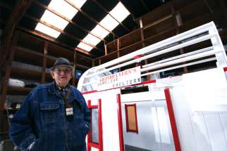 Vern Stuewe, 90, of Corvallis, Ore., poses for a photo Jan. 21 next to his prototype of a mobile shelter for the homeless. He has spent a year designing the sturdy and inexpensive living quarters.