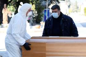 Men in Bergamo, Italy, transport a coffin of a person who died from the coronavirus disease in this photo shot March 16, 2020. A number of priests and religious women have been among the nearly 2,000 people who have died in Italy because of illness connected with COVID-19.