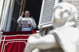 Pope Francis waves as he leads the Angelus from the window of his studio overlooking St. Peter&#039;s Square July 15 at the Vatican. 