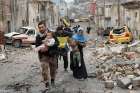 An Iraqi special forces soldier helps a family carry their child to cross from an Islamic State-controlled part of Mosul to an area controlled by Iraqi forces during a March 4 battle in Mosul.