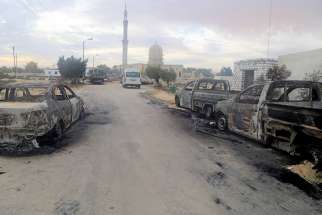 Damaged vehicles are seen Nov. 25 after a bomb attack at Al-Rawdah Mosque in Bir al-Abd, Egypt.