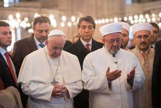 Pope Francis prays with Istanbul&#039;s grand mufti Rahmi Yaran during a visit to the Sultan Ahmed Mosque, also known as the Blue Mosque, in Istanbul Nov. 29.