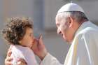 Pope Francis blesses a baby as he arrives to lead the Sept. 26 general audience in St. Peter&#039;s Square at the Vatican. 