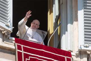 Pope Francis greets the crowd as he leads the Angelus from the window of his studio overlooking St. Peter&#039;s Square at the Vatican Nov. 1, 2020.