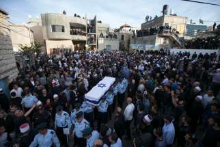 Israeli police officers carry the flag-draped coffin of Officer Zidan Nahad Seif in the northern village of Yanuh-Jat Nov. 19. Seif, a Druze, was wounded Nov. 18 while trying to stop a synagogue attack by two Palestinians armed with a meat cleaver and a gun. Four Israeli Jews with dual citizenship were killed in the attack. Latin Patriarch denounces violence in his Christmas message. 