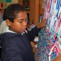 Working on the school’s loom, George Jenkins weaves plastic loops made from old milk bags to form a bed mat.