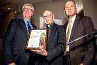 Catholic Civil Rights League president Phil Horgan, left, presents Fr. Tony Van Hee with the Exner Award, accompanied by CCRL executive director Christian Elia.