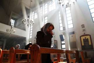 An Assyrian woman prays at a church in Damascus March 1 during a special Mass for Assyrian Christians abducted by Islamic State fighters. In early August, Islamic State militants attacked Qaryatain, a town where Christians sought refuge after leaving Aleppo, and Hawwarin, a nearby Assyrian village, where 2,000 Assyrian Christians were forced to flee.