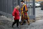 A homeless woman walks past a Swiss guard as she enters the Vatican March 26. While enjoying a private visit to the Sistine Chapel, homeless people were surprised by a visit from Pope Francis.