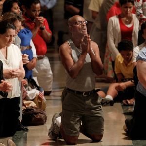 A man prays amid the overflow crowd during Mass at the Basilica of the National Shrine of the Immaculate Conception in Washington July 4, the final day of the bishops&#039; &quot;fortnight for freedom&quot; campaign. The observance, which began with a June 21 Mass in B altimore, was a two-week period of prayer, education and action on preserving religious freedom in the U.S.