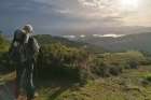 A pilgrim stands on a mountain and looks into the vastness of the Galician landscape during his hike on the “Camino Primitivo” (one of the paths of the Camino de Santiago) in Spain.