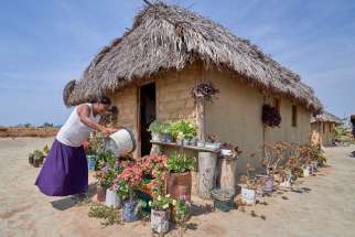 Celestina Fernandes da Silva, a Catholic activist, waters flowers in front of her home in the Wapishana indigenous village of Tabalascada, Brazil, April 3, 2019. Franciscan Father Joao Messias Sousa, who works among indigenous in the Amazon, said the people believe &quot;God is in all things, but those things are not gods.&quot;
