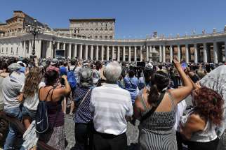 Pilgrims take pictures as Pope Francis leads the Angelus from the window of his studio overlooking St. Peter&#039;s Square July 8 at the Vatican.