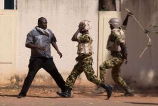 Soldiers hit an anti-government protester with a stick in Ouagadougou, Burkina Faso, Oct. 30. Burkina Faso&#039;s Catholic bishops sent a &quot;message of peace and hope&quot; to the West African country after its 27-year president, Blaise Compaore, fled prompting a mi litary takeover.
