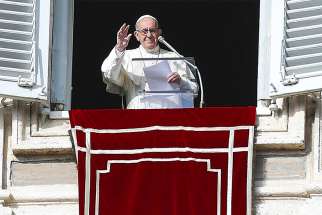 Pope Francis waves as he leads the Angelus from the window of his studio overlooking St. Peter&#039;s Square Dec. 9 at the Vatican. 