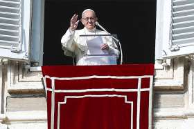 Pope Francis waves as he leads the Angelus from the window of his studio overlooking St. Peter&#039;s Square Dec. 9 at the Vatican. 