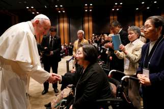 Pope Francis greets people as he arrives for a meeting with victims of the 2011 &quot;triple disaster&quot; (earthquake, tsunami and nuclear power plant meltdown) at Bellesalle Hanzomon, Tokyo, Japan, Nov. 25, 2019.