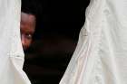 A Haitian refugee sticks his head out from a tent set up by the Canadian Armed Forces near Lacolle, Quebec, Aug. 10. Pope Francis released a statement Aug. 21 urging respect for the life and dignity of migrants and refugees.