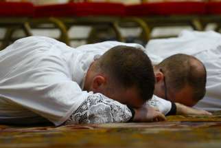 New deacons from the Pontifical North American College in Rome lie prostrate during their ordination in St. Peter’s Basilica Oct. 3.