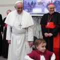 A child walks away after greeting Pope Francis during his visit to the Parish of San Cirillo Alessandrino in Rome Dec. 1. At right is Cardinal Agostino Vallini, papal vicar for Rome.