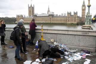 An injured woman is assisted after an attack on Westminster Bridge in London March 22. 