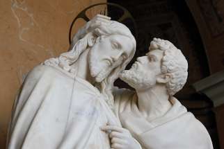 Judas kisses Jesus, an act of ultimate betrayal. 