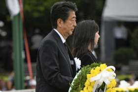 Japanese Prime Minister Shinzo Abe carries a wreath for the victims of the 1945 atomic bombing at Peace Memorial Park in Hiroshima, Japan, Aug. 6, 2019. The cermony marked the 74th anniversary of the bombing.