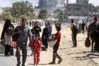 Smoke rises following an Israeli airstrike as displaced Palestinians make their way to flee areas in the eastern part of Khan Younis following an Israeli evacuation order, amid the ongoing Israel-Hamas war, in Khan Younis in the southern Gaza Strip Oct. 7. 