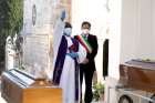 A priest blesses the coffins of two victims of COVID-19 during a burial ceremony in Italy.