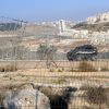 An Israeli border police jeep patrols along the Israeli separation fence and road that cuts off Palestinians from their olive groves near Bethlehem, West Bank, Dec. 22. The Israeli government, which will not allow them to cross the barrier, has declared them absentee landowners.