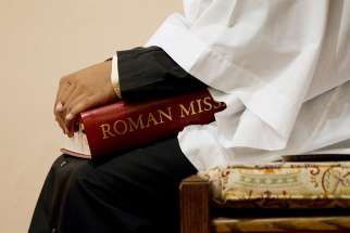 An altar server holds a copy of a Roman Missal during Mass at St. Joseph Catholic Church in Alexandria, Va., in this 2011 file photo. 