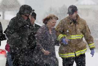 A woman is evacuated from a building where a shooter was suspected to be still holed up at a Planned Parenthood clinic Nov. 27 in Colorado Springs, Colo. Police say Robert Lewis Dear killed three people during the shooting rampage and hours-long standoff at the clinic and was later taken into custody.