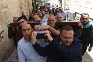  Men carry a large wooden cross during a procession on the Via Dolorosa, &quot;The Way of Sorrow,&quot; the path believed to be taken by Jesus Christ to his crucifixion on Calvary, on Good Friday April 14, 2017, in Jerusalem&#039;s Old City.