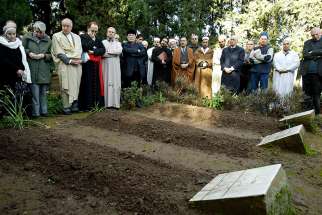 Cardinal Philippe Barbarin of Lyon, France, fourth from left, prays in 2007 in Medea, Algeria, during an interfaith service at the graves of the seven Trappist monks who were killed in 1996.