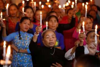 Women hold candles during a service at a church in My Khanh, Vietnam, Oct. 26, 2019, for 39 Vietnamese migrants found dead in the back of a truck at the Port of Tilbury in Essex, England. In a message to young Catholics in Vietnam, Pope Francis offered prayers for the migrants, who died while being smuggled into Great Britain in late October.