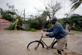 A man pushes a bicycle in floodwaters Oct. 4 in Les Cayes, Haiti, as Hurricane Matthew sweeps through the island nation.