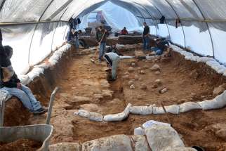 Workers slowly expose artifacts at the excavation site in the Russian Compound in Jerusalem. Slingstones on the ground are evidence of the battle that was waged at the site 2,000 years ago.