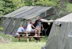 Refugees in Lacolle, Que., sit outside one of the tents set up to house the influx of asylum- seekers near the U.S. border Aug. 10, 2017.