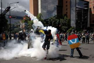 Opposition protesters clash with Venezuelan government forces June 22 in Caracas. A Venezuelan military police sergeant fatally shot a protester who was attacking the perimeter of an airbase, the interior minister said, bringing renewed scrutiny of the force used to control riots that have killed at least 76 people.