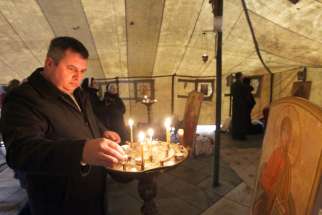 A man lights a candle in a temporary Ukrainian Catholic tent church in 2013 during anti-government protests in Kiev. Archbishop Sviatoslav Shevchuk of Kiev-Halych and other Ukrainian Catholic leaders have warned their church is being driven underground a gain, a quarter-century after it was re-legalized with the end of communist rule.