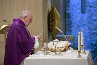Pope Francis holds the Eucharist during morning Mass in the chapel of his residence, the Domus Sanctae Marthae, at the Vatican April 9, 2019. The pope said the devil targets those who succumb to despair and negativity. 